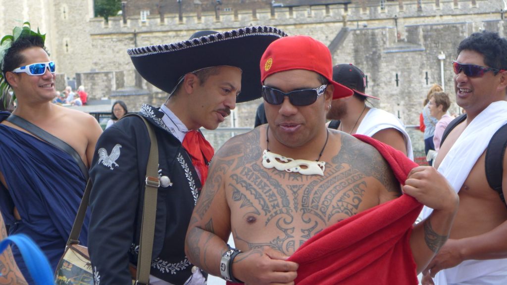 Mariachi al lado de un hombre con tatuajes
